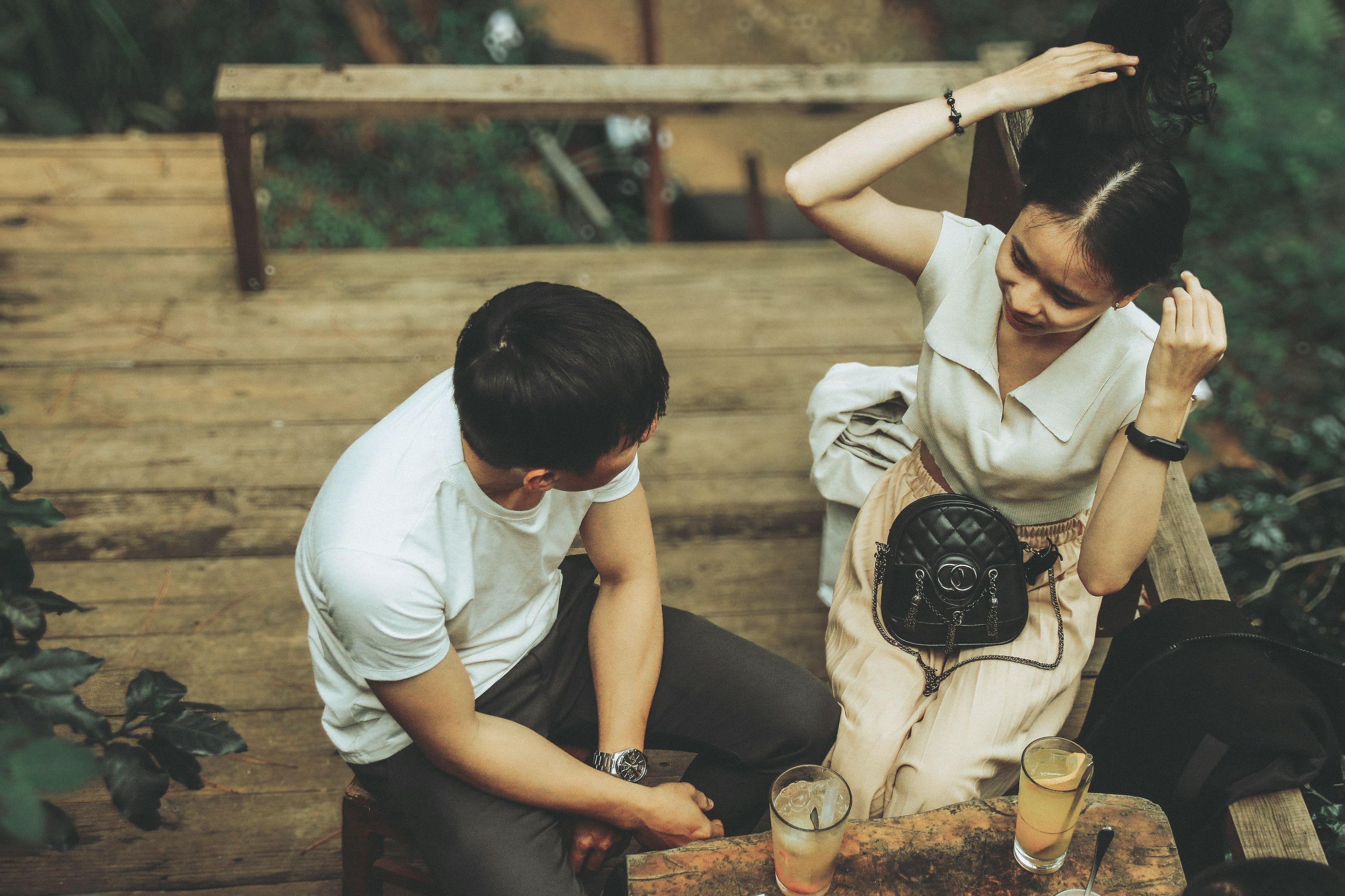 Couple enjoying drinks and conversation outdoors, reflecting relaxed and reciprocal dating dynamics.