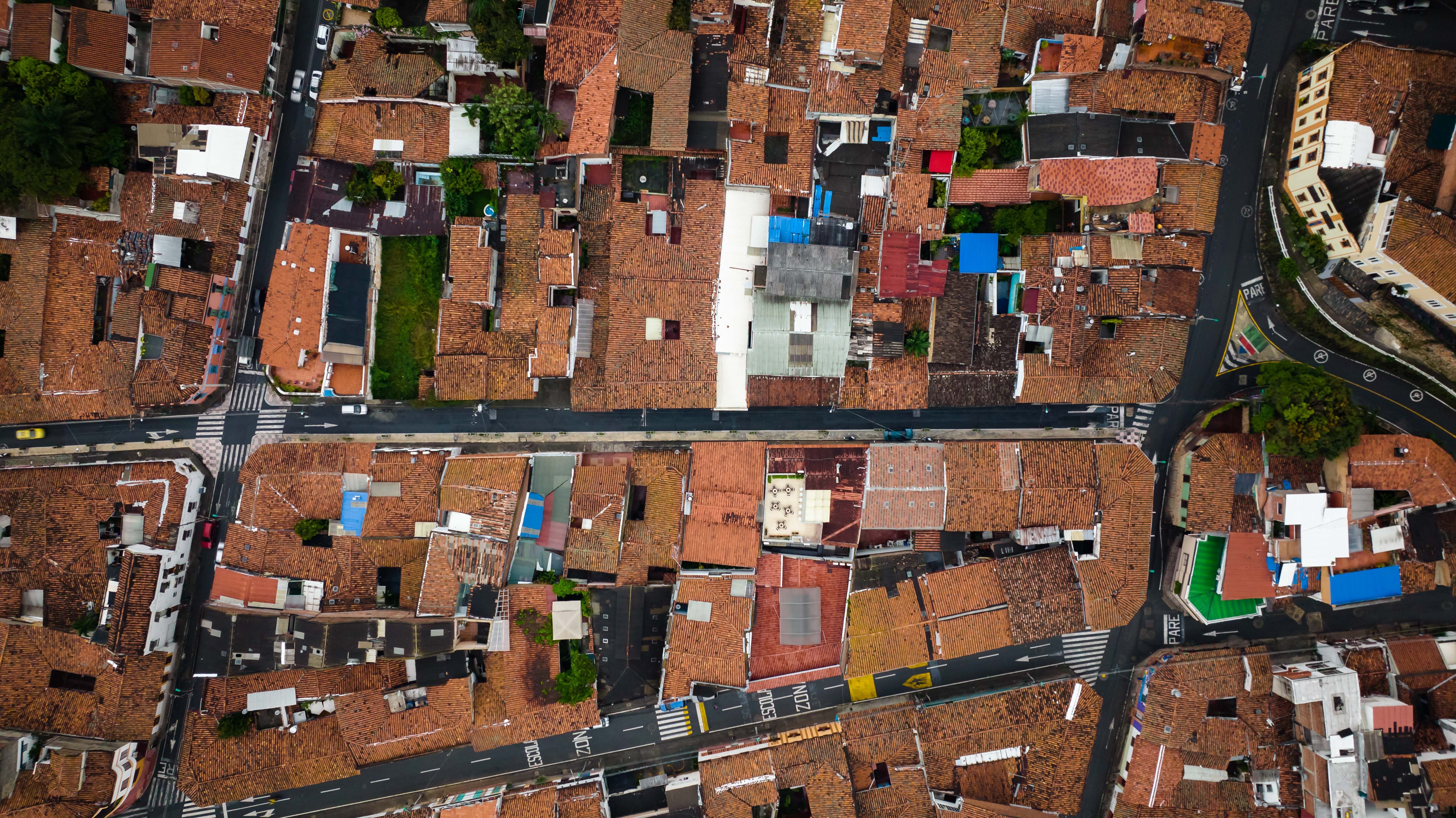 Aerial view of red-tiled rooftops and winding streets in a regional town